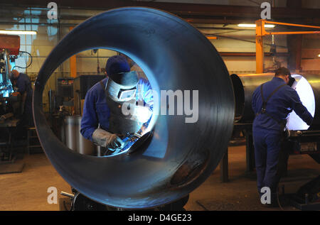 Un saldatore di opere su un grande tubo di metallo al contenitore Huch produttore in Werder, Germania, 11 marzo 2013. Huch costruisce Contenitori per immagazzinamento di calore. La società impiega 140 personale con uffici negli Stati Uniti e Cina. Foto: Bernd Settnik Foto Stock