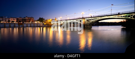 Siviglia, Spagna, il Ponte di Triana oltre il Guadalquivir nella luce della sera Foto Stock