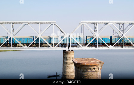 Treno merci passando attraverso la stazione di acciaio ponte che attraversa il fiume Krishna a Vijayawada , Andhra Pradesh , India Foto Stock