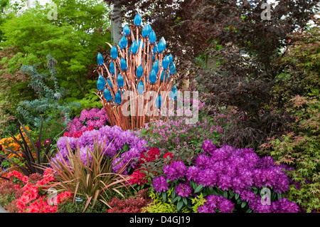 La molla confine con rododendri, arbusti e Arte Scultura su Hilliers esporre alla RHS Chelsea show 2010 si prega di credito Foto Stock