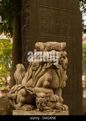 Uno di una coppia di Koma inu, o lion-cani, guardiani contro gli spiriti del male ad un sacrario scintoista in Saitama, Giappone. Foto Stock