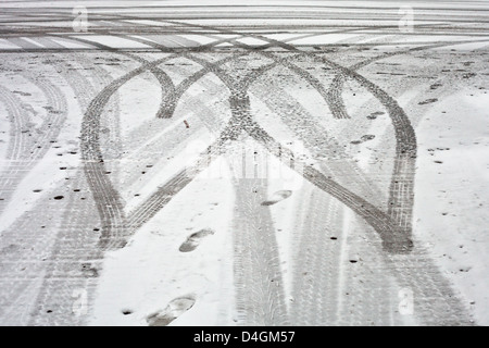 A forma di cuore le tracce dei pneumatici nella neve Foto Stock