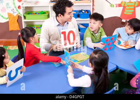 Insegnante di scuola materna per insegnare ai bambini la matematica Foto Stock