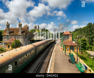 Un treno a vapore che tira in alla stazione di Corfe Castle nel Dorset Foto Stock