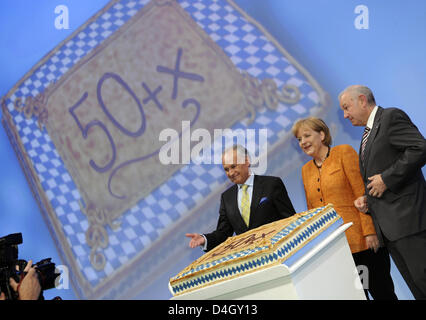 Il cancelliere tedesco Angela Merkel (C) è presentato con una fetta di torta in occasione del suo 54mo compleanno accanto al Primo Ministro bavarese Guenther Beckstein (R) e CSU Presidente Erwin Huber (L) in corrispondenza della CSU congresso di partito in Nuremberg, Germania, 18 luglio 2008. Il congresso si svolgerà fino al 19 luglio 2008. Foto: Peter Kneffel Foto Stock