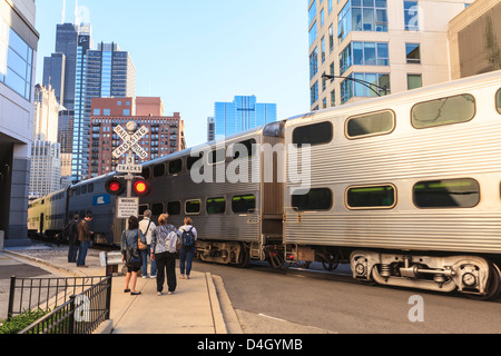 Metra treno passa i pedoni in corrispondenza di un apertura di attraversamento ferroviario, Downtown Chicago, Illinois, Stati Uniti d'America Foto Stock