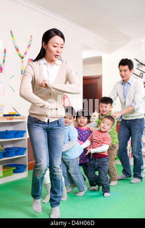 Felice kindergarten i bambini e gli insegnanti i giochi Foto Stock