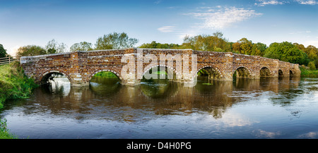 Una storica ironstone ponte sul fiume Stour a Sturminster Marshall, vicino a Wimborne Minster e ripetutamente il più antico ponte Foto Stock