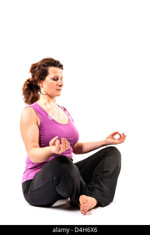 Bella donna esegue una meditazione nella posizione del loto. Foto Stock