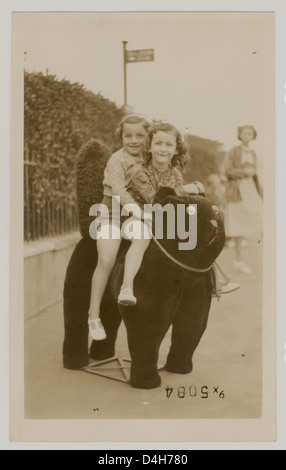 Le ragazze giovani seduti su un gatto ripiene di avere la loro vacanza fotografia scattata al mare, Margate,Kent, Regno Unito Degli anni trenta. Foto Stock