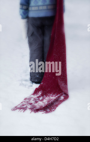 Una ragazza con una sciarpa rossa nella neve Foto Stock