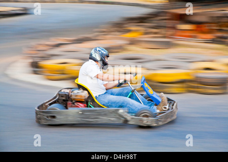 Prendere orizzontale di un driver asiatici e go kart come hanno passato zoom su una gara pubblica via in Goa in India Foto Stock