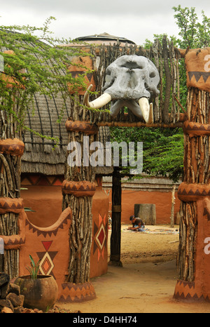 Di Eshowe, KwaZulu-Natal, Sud Africa, elefante cranio con zanne sopra l'ingresso, la struttura decorativa, Shakaland, tema culturale villaggio, persone Foto Stock