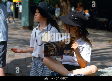 Sydney NSW Australia scuola bambini indossare Cappello da sole guardando la guida al Taronga Zoo Foto Stock