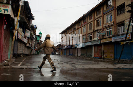 Srinagar, Indiano Kashmir amministrato, giovedì 14 marzo 2013. La polizia indiana uomo protezioni strade deserte durante un coprifuoco a Srinagar la capitale estiva di Indiano Kashmir amministrato, India. Le autorità indiane ha imposto il coprifuoco in Kashmir per contrastare la manifestazione di protesta dopo che hanno ucciso un 34 anno vecchio mercoledì. Foto di Sofi Suhail/Alamy) Foto Stock