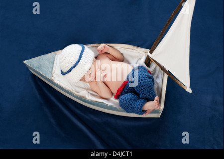 Neonato Boy Sailor dormire in una barca Foto Stock