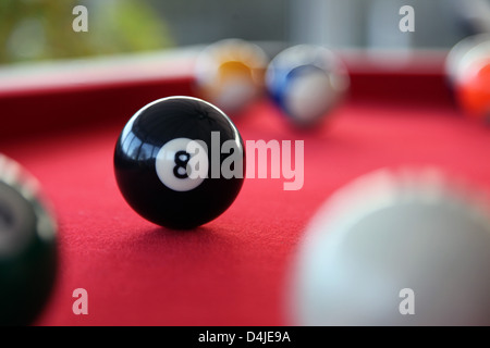 Si tratta di una foto di un biliardo o biliardo con tappeto rosso. Siamo in grado di vedere le sfere 9, 11, 8 e quello bianco. Si tratta di un gioco al coperto Foto Stock