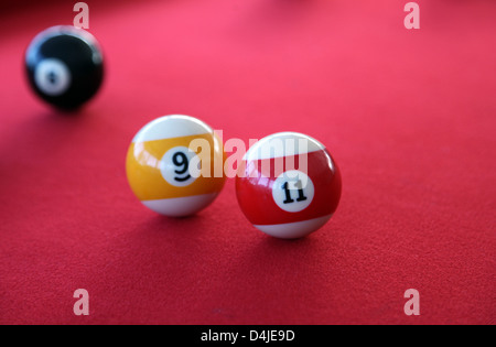 Si tratta di una foto di un biliardo o biliardo con tappeto rosso. Siamo in grado di vedere le sfere 9, 11, 8 e quello bianco. Si tratta di un gioco al coperto Foto Stock