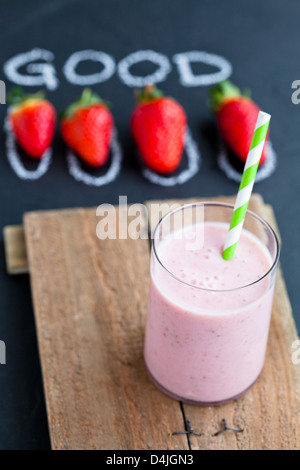 Frullato di fragole con paglia a strisce e fragole intere Foto Stock