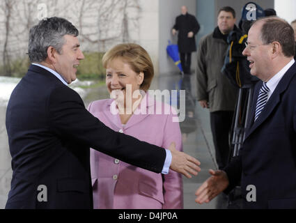 Il primo ministro britannico Gordon Brown è accolto dal ministro delle finanze tedesco Peer Steinbrueck (R) e il Cancelliere tedesco Angela Merkel (C) in occasione di una conferenza dei leader dell'UE poteri economici presso la cancelleria di Berlino, Germania, 22 febbraio 2009. I politici dell'UE hanno partecipato a una riunione speciale per cercare di trovare una posizione comune sulla crisi economica nella scia del prossimo G20 world f Foto Stock