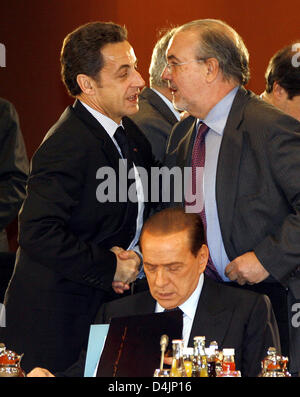 Il Presidente francese Nicolas Sarkozy (L), il Primo Ministro italiano Silvio Berlusconi (C) e il Primo Ministro spagnolo Pedro Solbes (R) chat all'inizio di una conferenza dei leader dell'UE poteri economici presso la cancelleria di Berlino, Germania, 22 febbraio 2009. I politici dell'UE hanno partecipato a una riunione speciale per cercare di trovare una posizione comune sulla crisi economica e sui metodi di controllo Foto Stock