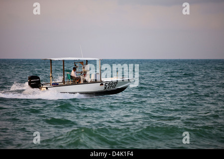 Un pescatore nella sua barca di uscire al mattino presto a Key West Foto Stock