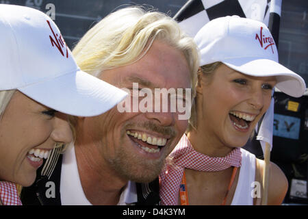 Proprietario di Virgin di Sir Richard Branson (C) ride insieme con due modelli durante il 2009 FORMULA ONE Grand Prix all'Albert Park circuito di Melbourne, Australia, 28 marzo 2009. La Formula Uno Australian Grand Prix avrà luogo domenica 29 marzo. Foto: Jens BUETTNER Foto Stock