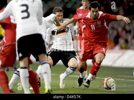 Germania?s Bastian SCHWEINSTEIGER (L) e Galles? Joe Ledley si contendono la palla durante le qualificazioni ai Mondiali di Galles vs Germania al Millennium Stadium di Cardiff, Regno Unito, 01 aprile 2009. La Germania ha sconfitto il Galles 2-0. Foto: Peter Kneffel Foto Stock