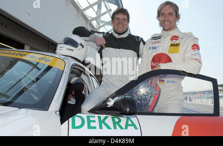 Il tedesco ex campione di ciclismo Jan Ullrich (L) e ski jumping campione tedesco Sven Hannawald (R) pongono durante un test e unità di formazione con una Porsche Carrera al circuito di Hockenheim vicino a Hockenheim, Germania, 07 aprile 2009. Entrambi competere in gare di volta in volta, Ullrich è andando a correre la 24 Ore del Nurburgring . Foto: Ronald Wittek Foto Stock