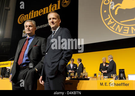 Il presidente del consiglio di vigilanza di Continental AG, Rolf Koerfer (L), e CEO Karl-Thomas Neumann (R) stand di fronte il logo dell'azienda all'inizio dell'assemblea degli azionisti a Hanover?s centro congressi, Germania, 23 aprile 2009. La riunione è accompagnata da massicce proteste dei dipendenti contro i previsti tagli di posti di lavoro. Il sindacato IG BCE prevede 2.500 a 3.000 lavoratori da Fre Foto Stock