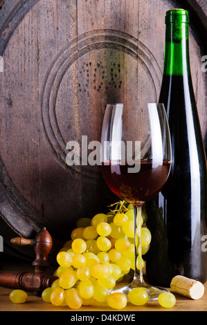 Assortimento con uve, vetro e una bottiglia di vino rosso e il barile di legno Foto Stock