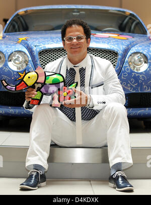 Artista brasiliano Romero Britto detiene una delle sue sculture di fronte una Bentley Continental GT progettata da lui stesso in ?Automobil Forum Unter den Linden? A Berlino, Germania, 09 luglio 2009. La vettura è visualizzato in una mostra nel forum fino al 06 settembre 2009, prima che possa essere messo all'asta per la carità. Foto: TIM BRAKEMEIER Foto Stock