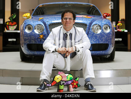 Artista brasiliano Romero Britto si siede di fronte a una Bentley Continental GT progettata da lui stesso con una delle sue sculture in ?Automobil Forum Unter den Linden? A Berlino, Germania, 09 luglio 2009. La vettura è visualizzato in una mostra nel forum fino al 06 settembre 2009, prima che possa essere messo all'asta per la carità. Foto: TIM BRAKEMEIER Foto Stock