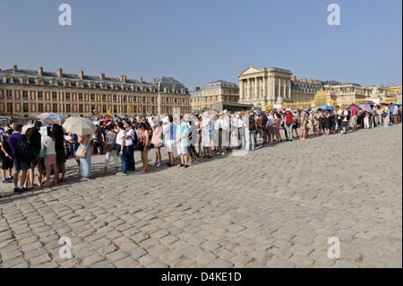 Lunga coda di turisti al di fuori del Palazzo di Versailles, Francia. Foto Stock