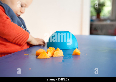 Baby boy mangiare la frutta da tavola Foto Stock