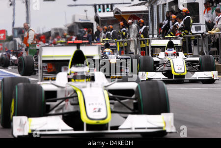 British driver di Formula Uno Jenson Button della Brawn GP (L) e il compagno di squadra brasiliano Rubens Barrichello (R) sterzare le loro auto nella pitlane durante la sessione di qualifiche per il Gran Premio di Germania al Nurburgring in Nuerburg, Germania, 11 luglio 2009. Formula 1 Gran Premio di Germania si svolgerà domenica 12 luglio. Foto: Jens BUETTNER Foto Stock