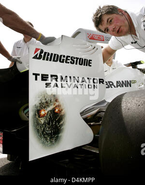 Meccanica della Brawn GP per spingere il brasiliano pilota di Formula Uno Rubens Barrichello torna in squadra?s garage dopo la terza sessione di prove libere sul Circuito de Catalunya di Montmelo vicino a Barcellona, Spagna, 09 maggio 2009. La Brawn GP campagne per il nuovo film "Terminator Salvation? Per premiere in Europa il 28 maggio 2009 a Parigi, Francia. Il Gran Premio di Spagna si svolgerà il 10 maggio. Foto: Feli Foto Stock