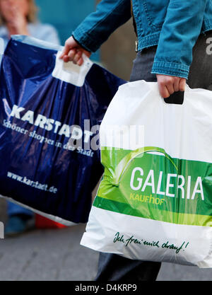 Una donna porta sacchetti di entrambi i magazzini Karstadt e Kaufhof a Colonia, Germania, 18 maggio 2009. Kaufhof casa madre del gruppo METRO rende un anticipo di unire la Germania?s due maggiori delle catene di grandi magazzini Kaufhof con Karstadt, un subisdiary di Arcandor. Foto: OLIVER BERG Foto Stock