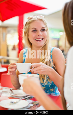 Le donne aventi un caffè a sidewalk cafe Foto Stock