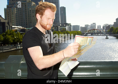 L'uomo la lettura di una mappa della città sul ponte Foto Stock