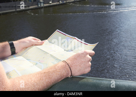 L'uomo la lettura di una mappa della città sul ponte Foto Stock