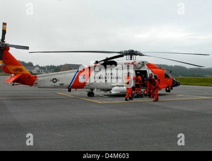 La squadra della stazione aerea Kodiak ha salvato con successo i membri dell'equipaggio dal peschereccio Bear con un elicottero MH-60 Jayhawk. L'operazione di salvataggio ha avuto luogo nelle dure condizioni delle acque dell'Alaska, mostrando la capacità della Guardia Costiera di eseguire missioni salvavita in ambienti estremi. Foto Stock