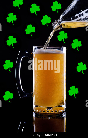 Un studio immagine di un boccale di birra con trifogli in background. Foto Stock