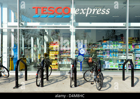 Tesco Express supermercato vetrina di un negozio di biciclette con parkin Foto Stock