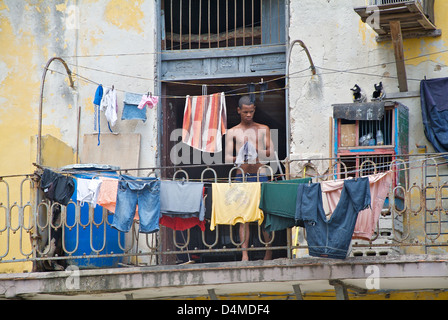 L'Avana, Cuba, un uomo si blocca servizio lavanderia sul balcone Foto Stock