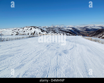 Guardando verso il basso curato ski run a glenshee, aberdeenshire Foto Stock