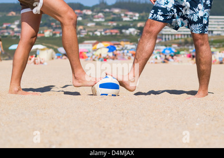 Due persone stepping una sfera sulla spiaggia. La foto è stata scattata in un pomeriggio soleggiato, a livello del terreno Foto Stock