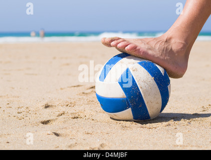 Passo passo di piede su una sfera sulla spiaggia. Essa mostra un close-up e la foto è stata scattata a livello del suolo Foto Stock