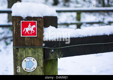 Un rosso bridleway segno su una recinzione in inverno. Foto Stock