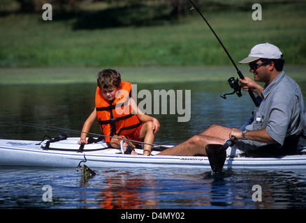 Padre e figlio di prendere un largemouth bass (micropterus salmoides) su un piccolo laghetto nei pressi di Austin in Texas Foto Stock